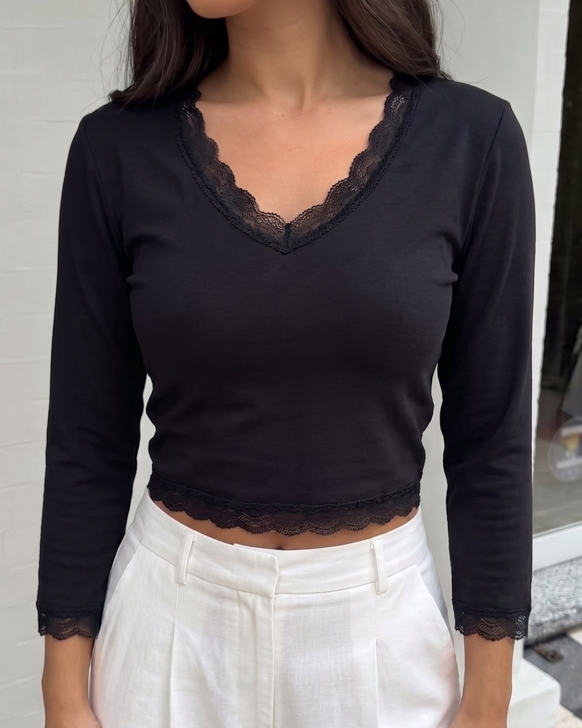 AURRA Cropped V Lace Top in black, worn with white linen trousers