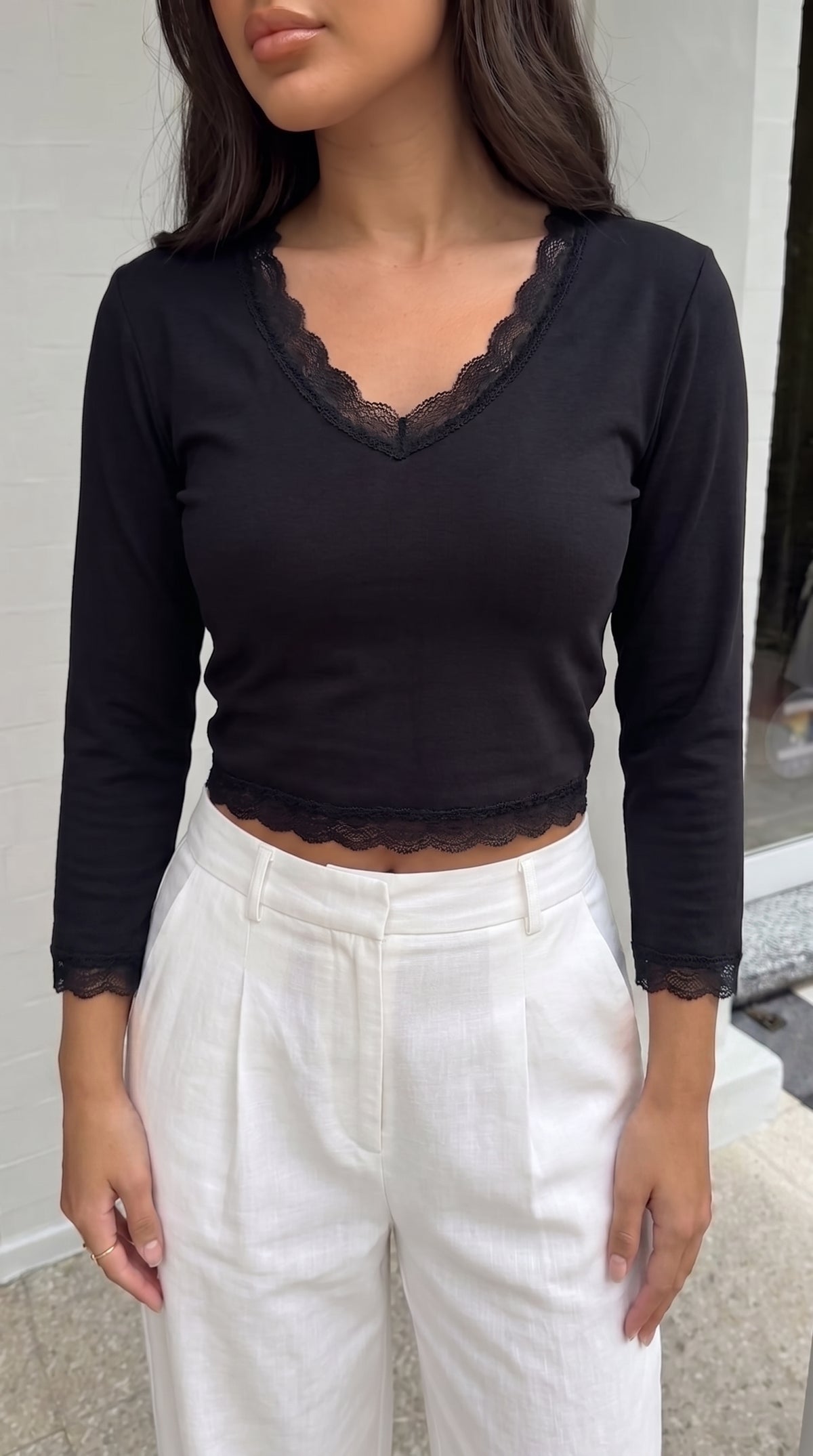 AURRA Cropped V Lace Top in black, worn with white linen trousers